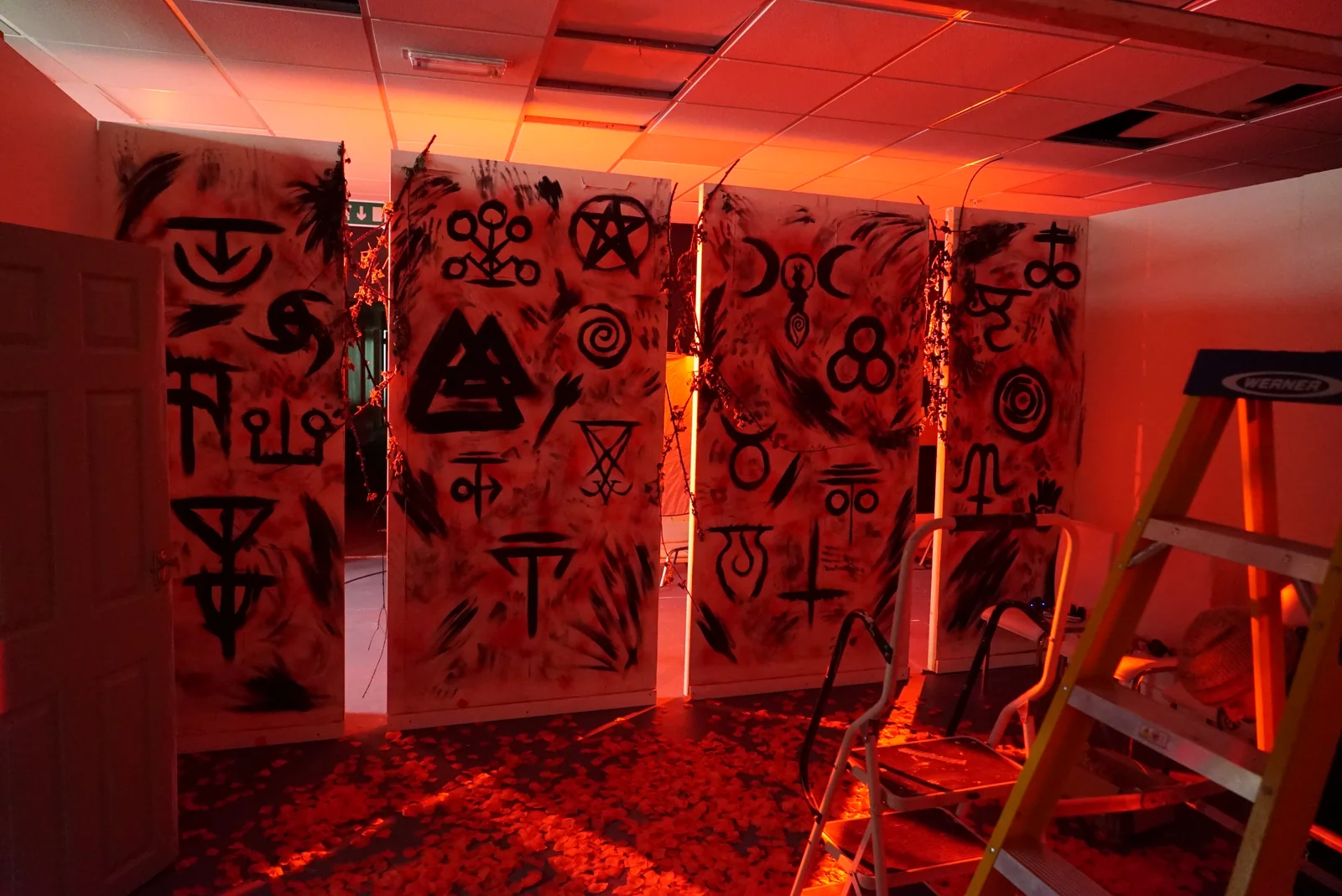 The red-lit set with painted symbols, lights and a ladder