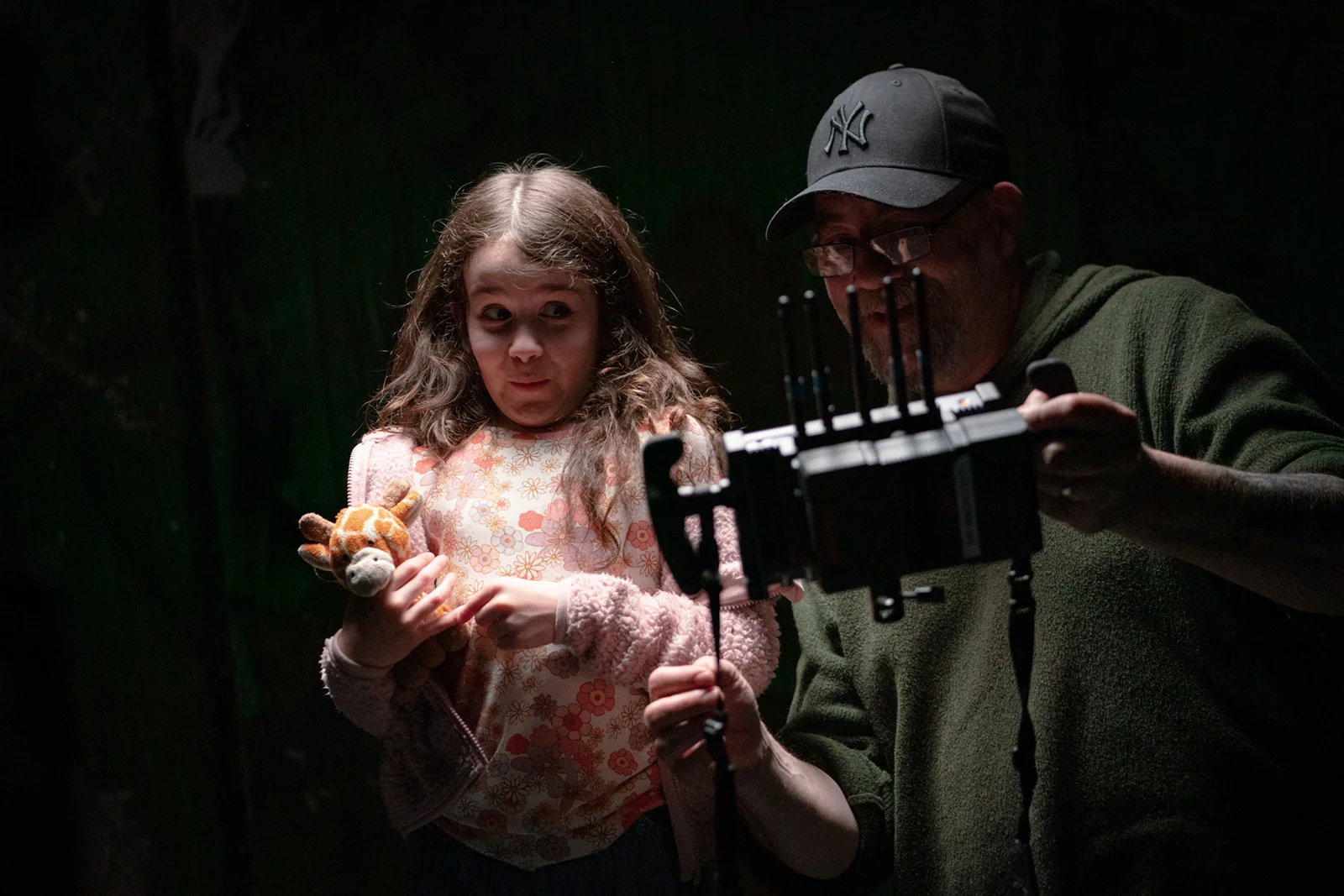 A child performer and crew member looking at the camera monitor